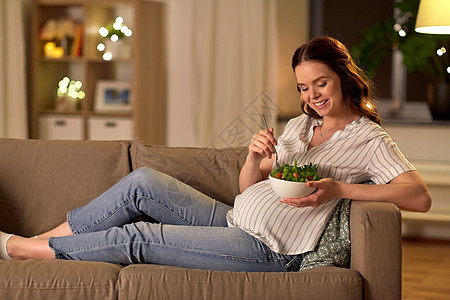 怀孕,健康的食物人们的快乐的微笑孕妇家吃蔬菜沙拉快乐微笑的孕妇家吃沙拉背景