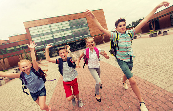 小学教育,友谊,童年人的群快乐的小学生,背包户外跑步挥手群快乐的小学生跑步图片