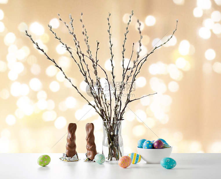 复活节,假日象猫柳枝,彩色鸡蛋巧克力兔子桌子上的节日灯光背景阴柳,复活节彩蛋巧克力兔子图片