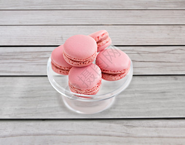 糖果糕点食品玻璃糖果上的粉红色马卡龙站背景上的灰色板上玻璃糖果摊上的粉红色马卡龙图片
