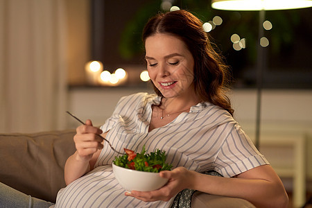 怀孕,健康的食物人们的快乐的微笑孕妇家吃蔬菜沙拉快乐微笑的孕妇家吃沙拉图片