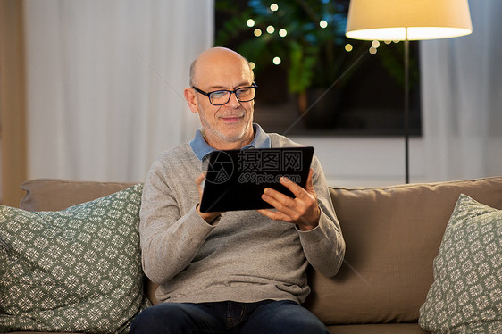 老人拿着平板电脑坐沙发上图片