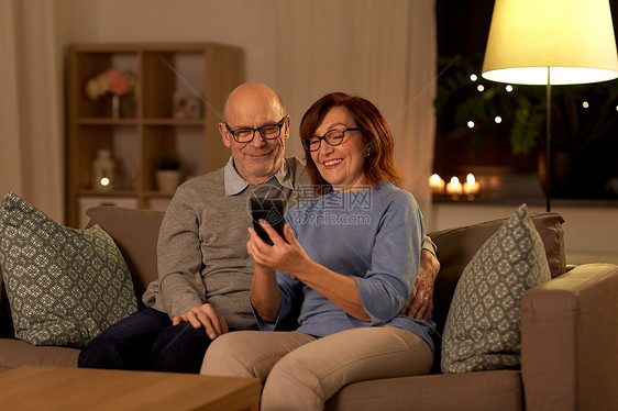 技术,老年人人的快乐的老年夫妇家里的智能手机晚上幸福的老年夫妇家里有智能手机图片