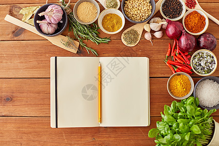 食物,烹饪饮食笔记本与铅笔同的香料,洋葱,大蒜与松子红色辣椒木桌上木制桌子上有铅笔香料的笔记本图片
