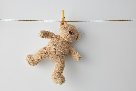 童年洗衣柔软的泰迪熊玩具挂白色背景的晾衣绳上柔软的泰迪熊玩具挂晾衣绳上图片