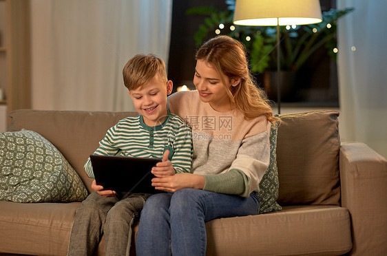 家庭技术人的快乐的母亲小儿子坐沙发上,家用平板电脑母子家里用平板电脑图片