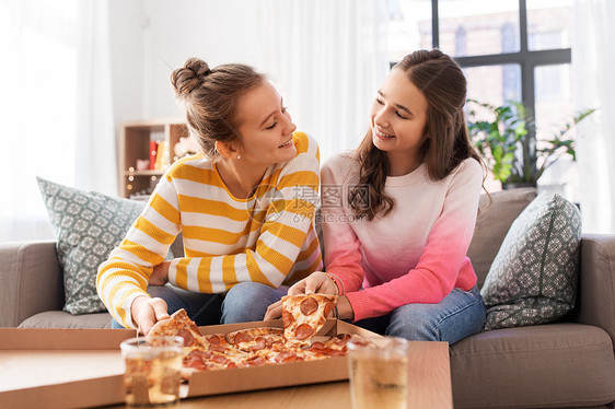 人,食物友谊的快乐的十几岁的女孩家里吃外卖比萨饼快乐的十几岁的女孩家吃外卖披萨图片