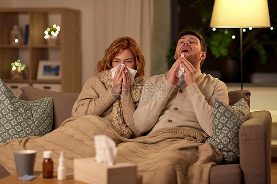 健康,流感人们的生病的年轻夫妇,家里吹鼻子打喷嚏生病的年轻夫妇家里用纸巾吹鼻子图片