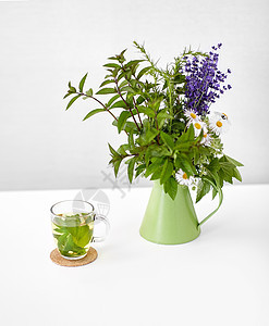 生态有机草本茶花绿色水壶白色背景凉茶罐子里的花背景图片