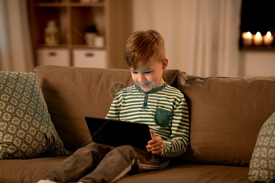 童年,技术人的快乐的微笑小男孩与平板电脑电脑家里晚上家里有平板电脑的快乐小男孩图片