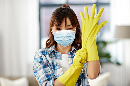 清洁健康卫生亚洲妇女戴防护医学面具,以防止病疾病,并家里戴上橡胶手套戴防护面罩橡胶手套的亚洲女人图片