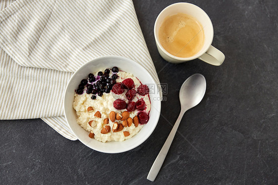 食物早餐粥碗与野生浆果,杏仁坚果,勺子咖啡石板石桌粥早餐加浆果,杏仁勺子图片