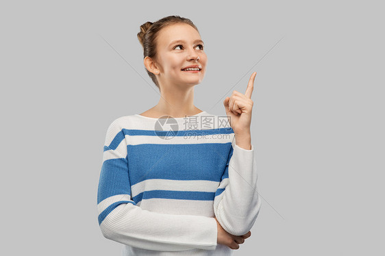 想法人的微笑的十几岁女孩套衫上指着灰色的背景穿着套衫的快乐少女指着手指图片