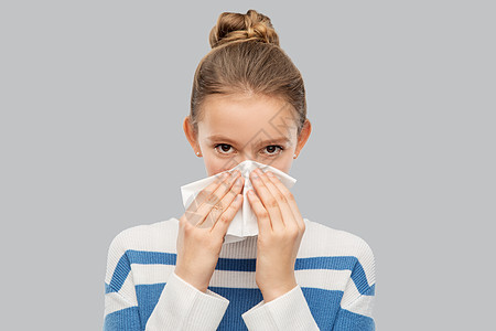 健康,鼻炎人的生病的十几岁女孩用纸纸巾灰色背景下吹鼻涕生病的十几岁女孩用纸巾吹鼻子图片