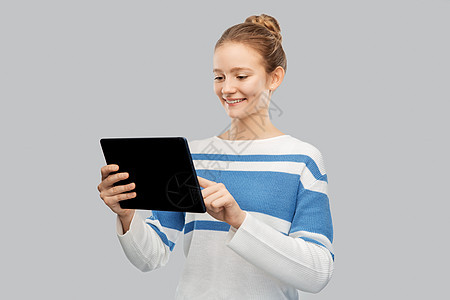 技术,沟通人的快乐的微笑少女套衫用平板电脑电脑灰色背景快乐微笑的十几岁女孩用平板电脑图片