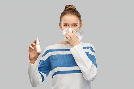 健康,鼻炎人的生病的十几岁女孩用纸巾吹鼻涕,并灰色背景上用鼻喷雾剂恶心的十几岁女孩用鼻喷鼻背景图片
