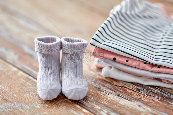 婴儿期服装婴儿衣服木桌上把婴儿衣服放木桌上图片