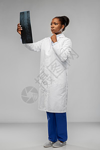 医学,外科医疗保健非裔美国女医生或外科医生穿着白色外套,灰色背景下看X光非裔美国女医生看X光图片