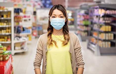 健康安全,检疫大流行亚洲年轻妇女戴着保护医疗面具,以防止蓝色背景下的病疾病戴防护医学面具的亚洲年轻女子图片