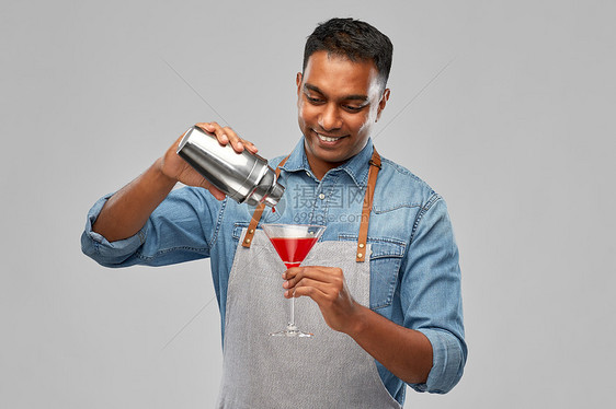 酒精饮料,人职业印度酒吧服务员围裙倒鸡尾酒床到玻璃灰色背景印度酒吧男招待,杯鸡尾酒壶图片