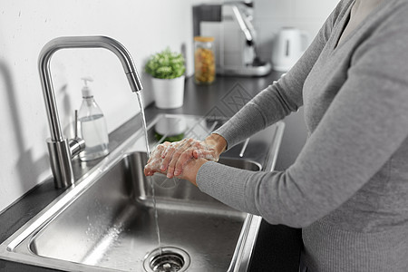 卫生保健安全家里厨房用液体肥皂洗手女人厨房里用液体肥皂洗手图片
