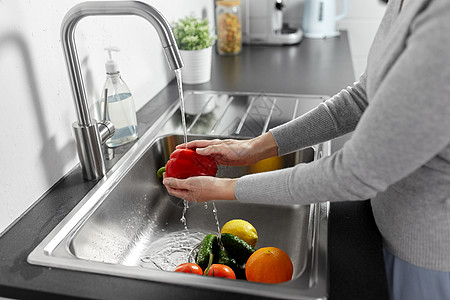 卫生保健安全密切妇女厨房里洗水果蔬菜女人厨房洗水果蔬菜图片