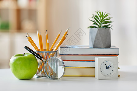 教育学校书籍,放大镜,铅笔,种植花盆与绿色苹果闹钟家里家里桌子上的书,苹果图片