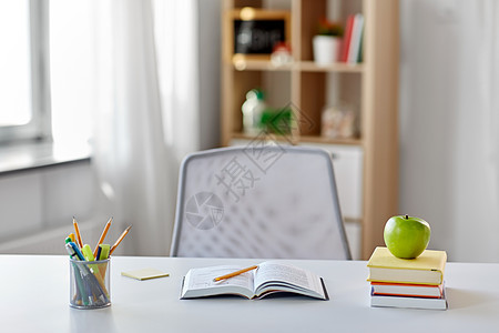 教育学书籍,苹果学校用品家里桌子上家里桌子上有书苹果学用品背景图片