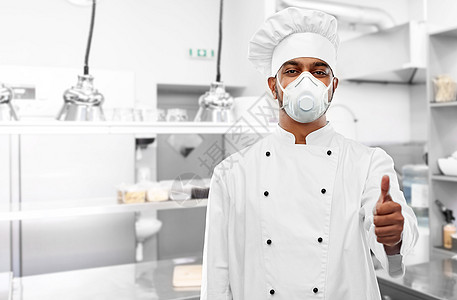 健康保护,安全大流行印度男厨师戴着面罩或呼吸器,餐厅厨房背景上竖起大拇指呼吸器厨师厨房竖起大拇指图片