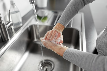 卫生保健安全家里厨房用液体肥皂洗手女人厨房里用液体肥皂洗手图片
