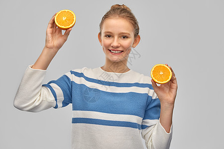 健康的饮食人们的微笑的少女套衫与橙色的半以上灰色背景带橘子穿套衫的微笑少女图片
