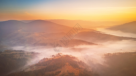 美丽秋山的空中全景日出山间雾谷上早上雾蒙蒙的林地乌克兰喀尔巴阡山脉图片