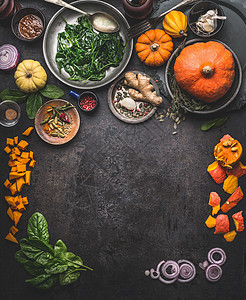 素食季节食物背景,配料为草药冬季烹饪南瓜,菠菜,生姜,洋葱上面的风景框架图片