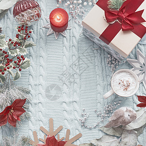圣诞背景与礼品盒,杯热巧克力,燃烧蜡烛节日装饰浅蓝色针织毛毯上面的风景假日平躺框架图片