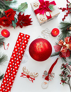 红色圣诞装饰包装纸白色桌子上,上面有冷杉树枝圣诞花上面的风景平躺图片
