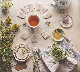 草药茶的健康的热饮各种新鲜的草药与杯凉茶,蜂蜜茶袋乡村的桌子背景上面的风景图片