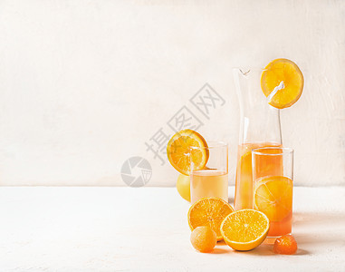 清爽的橙色柠檬水,水果,冰块,橙汁,水壶白色桌子上的眼镜图片