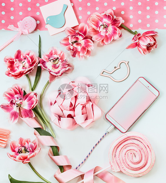 白色桌子上有粉红色花朵丝带的智能手机上面的风景母亲节生日空白屏幕问候技术图片