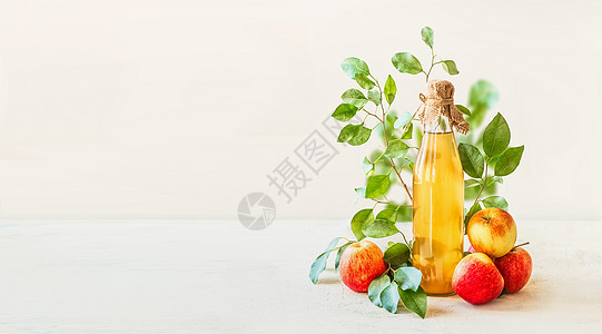 横幅与自制苹果醋玻璃瓶站白色桌子上,红色苹果绿叶白色的墙壁背景健康发酵食品保存苹果图片
