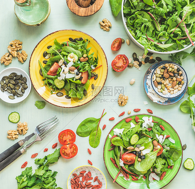 厨房桌子背景上有绿色沙拉的盘子,有叉子配料坚果种子幼叶橄榄油调料上面的风景节食夏季美食健康的家庭食品图片