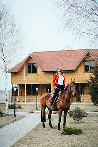 红发骑师女孩穿着红色开衫黑色高靴,带着匹马散步图片