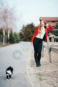 红发骑师女孩穿着红色开衫黑色高靴,带着只猫散步图片