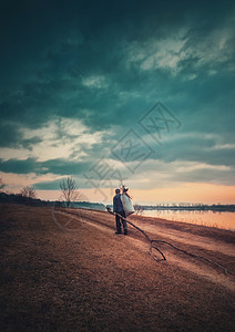 乡村傍场景,垂直的照片与个孤独的游牧男子携带木柴个袋他的肩膀,回家走湖边的条乡村土路喜怒无常戏剧的观点图片