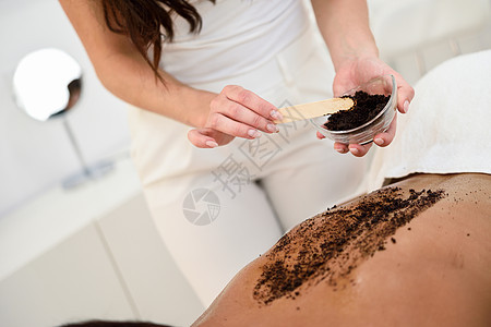 妇女水疗健康中心用咖啡擦洗身体的皮肤美美学图片