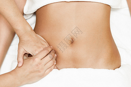 手部按摩女腹部的顶部视图治疗师腹部施加压力水疗沙龙接受按摩的女人双手按摩女腹部治疗师腹部施加压力图片