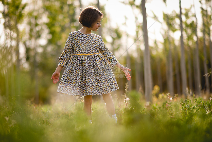 小女孩穿着漂亮的衣服走大自然的田野里大自然领域的小女孩穿着漂亮的衣服图片