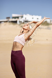 高加索女人海滨练瑜伽年轻的女西牙的卡迪兹安达卢西亚的海滩上举起手臂高加索金发女人海滩上练瑜伽图片