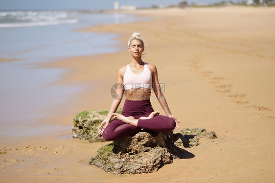 高加索女人海滨练瑜伽年轻的女西牙的卡迪兹安达卢西亚的海滩上做莲花姿势高加索金发女人海滩上练瑜伽图片