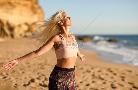西牙安达卢西亚的卡迪兹美丽的海滩上享受日落的女人年轻的女张开双臂呼吸大海的空气女人美丽的海滩上享受日落图片