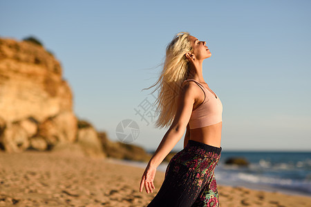 西牙安达卢西亚的卡迪兹美丽的海滩上享受日落的女人年轻的女张开双臂呼吸大海的空气女人美丽的海滩上享受日落背景图片